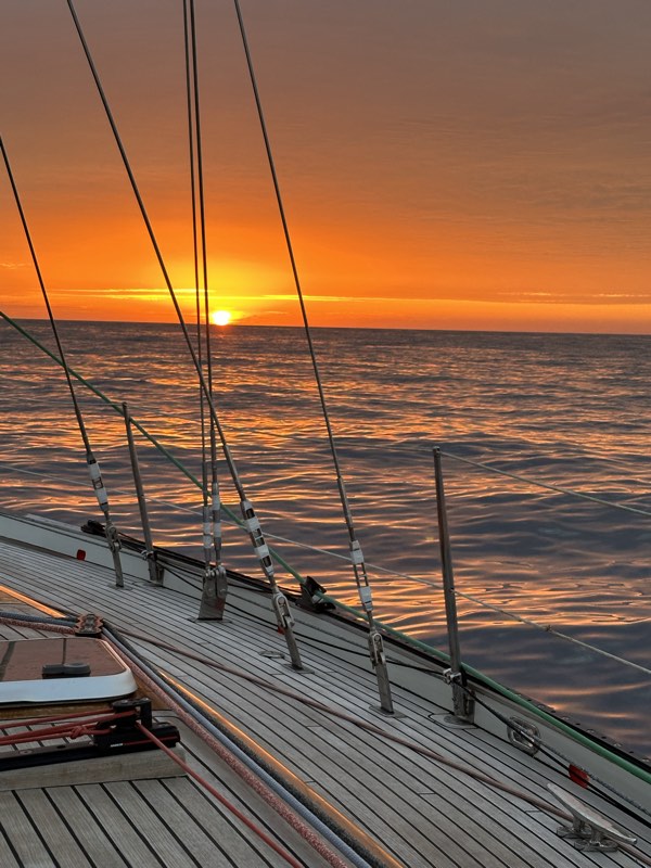 Tekowy pokład i reling o zachodzie słońca nad oceanem